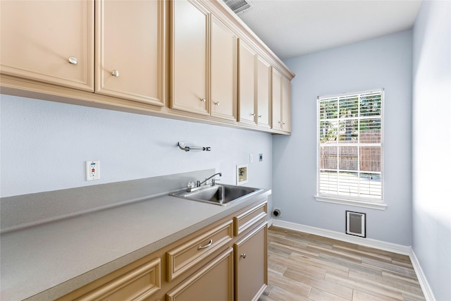 laundry area featuring hookup for an electric dryer, washer hookup, cabinets, sink, and light hardwood / wood-style flooring