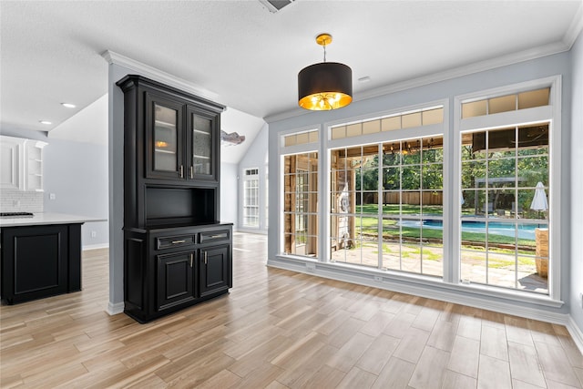 kitchen featuring decorative backsplash, vaulted ceiling, and ornamental molding