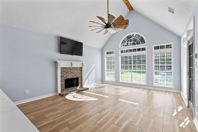 unfurnished living room with lofted ceiling with beams, a brick fireplace, and ceiling fan