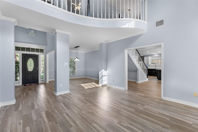 foyer with a notable chandelier, a high ceiling, and light wood-type flooring