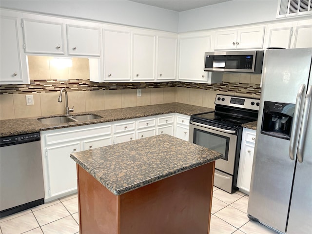 kitchen featuring dark stone counters, sink, appliances with stainless steel finishes, and white cabinetry