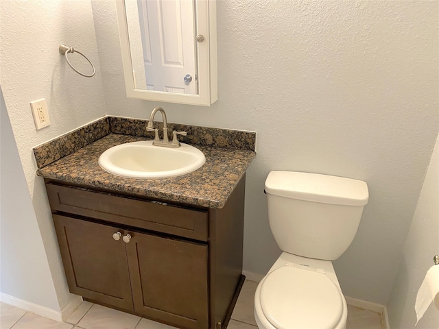 bathroom featuring tile patterned flooring, vanity, and toilet