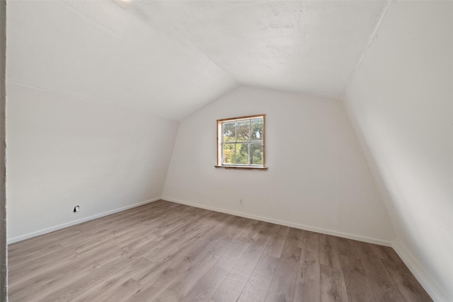 bonus room featuring baseboards, lofted ceiling, and light wood finished floors