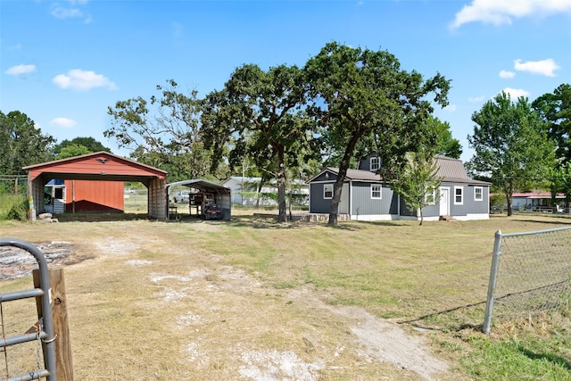 view of yard with a carport, driveway, and fence