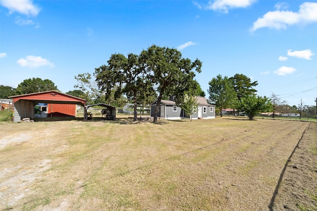 view of yard with a detached carport and dirt driveway