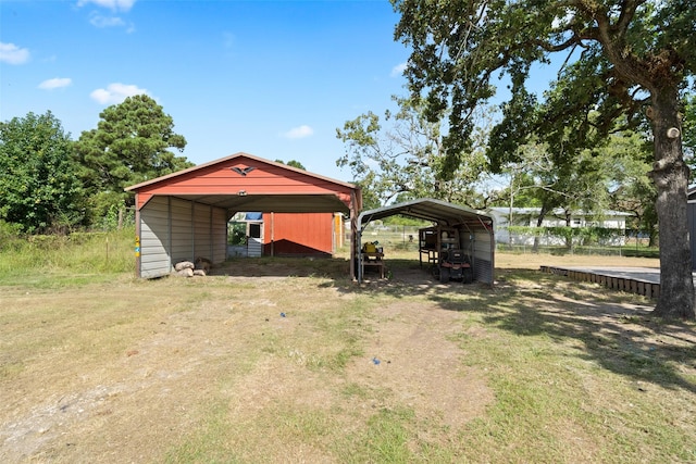 view of outbuilding with a detached carport and dirt driveway