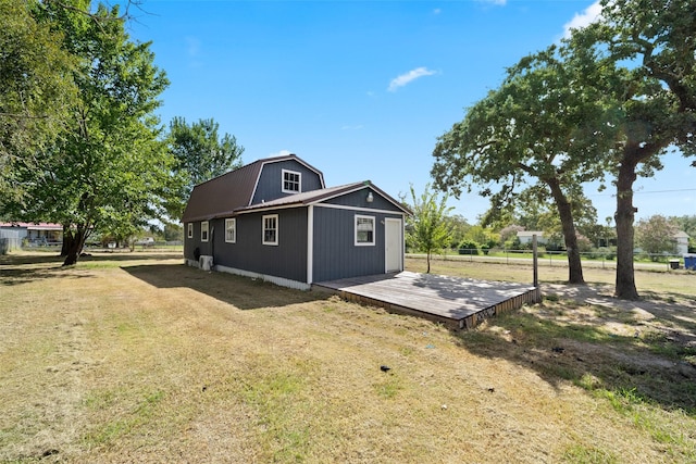 view of side of property with a lawn and a gambrel roof