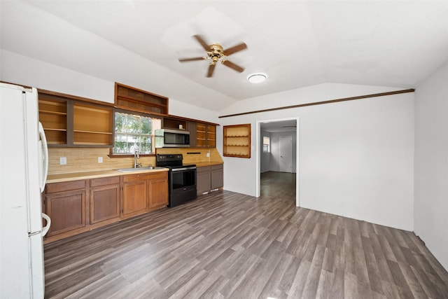 kitchen featuring open shelves, freestanding refrigerator, a sink, black range with electric cooktop, and stainless steel microwave