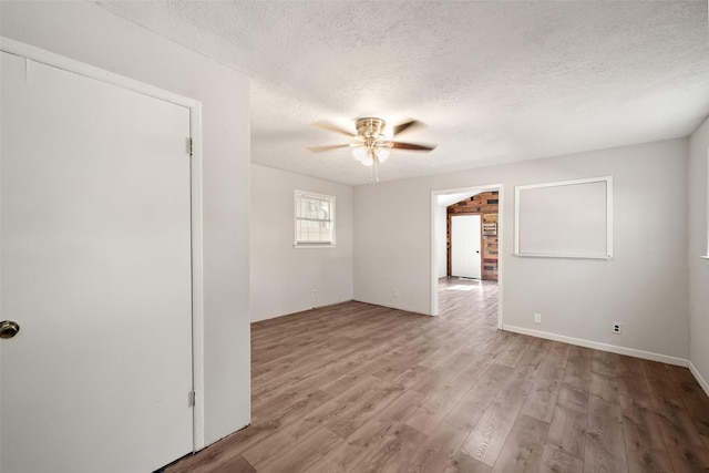 spare room with a ceiling fan, wood finished floors, and a textured ceiling