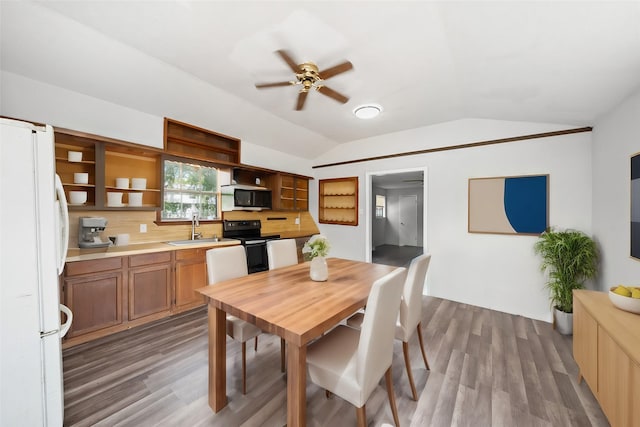 dining space featuring wood finished floors, a ceiling fan, and vaulted ceiling