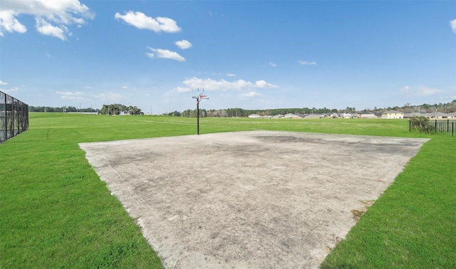 view of property's community featuring a lawn and basketball hoop