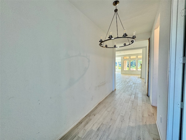 hall featuring vaulted ceiling, light hardwood / wood-style flooring, and a chandelier