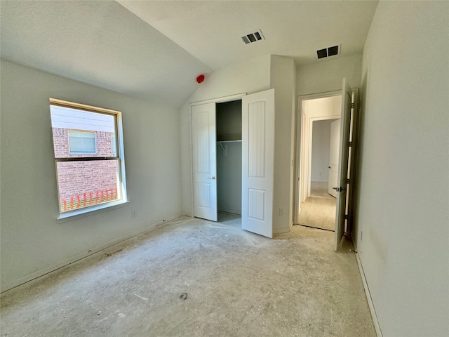 unfurnished bedroom with a closet and lofted ceiling