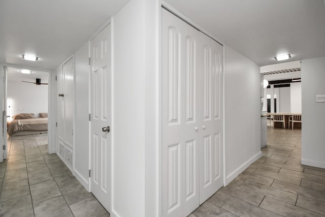 hall with a barn door and light tile patterned flooring