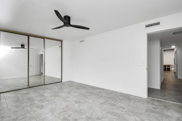 unfurnished bedroom with light tile patterned floors, ceiling fan, and a closet