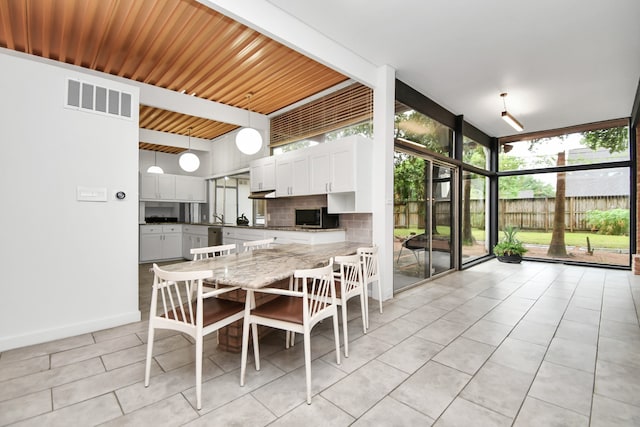 tiled dining space featuring wood ceiling and a wall of windows