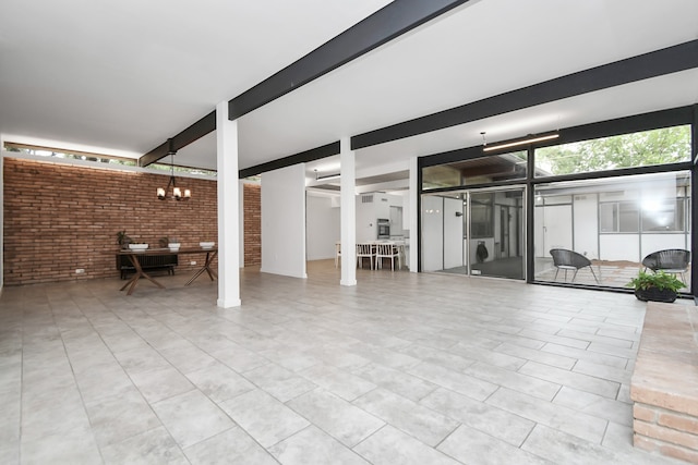 interior space featuring brick wall, a notable chandelier, and light tile patterned flooring