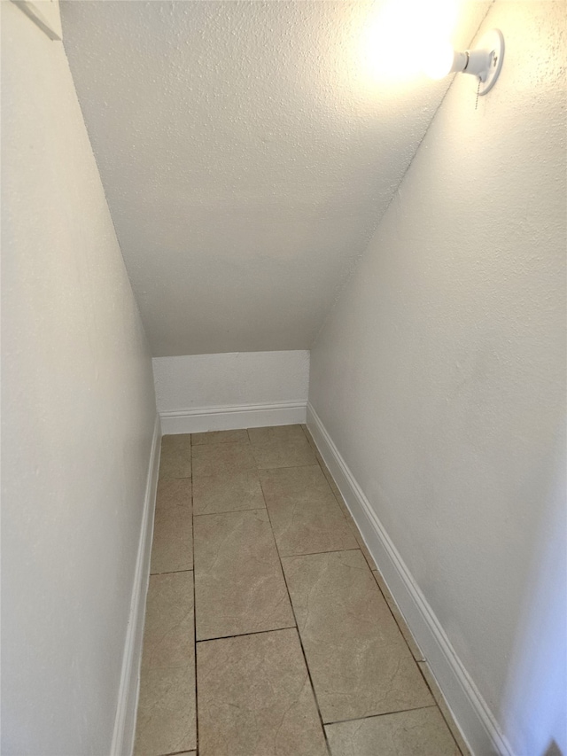 bonus room with a textured ceiling and light tile patterned floors