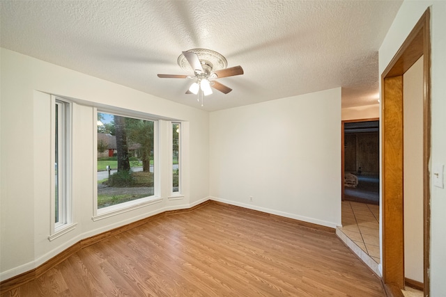 unfurnished room featuring a textured ceiling, ceiling fan, and light hardwood / wood-style floors