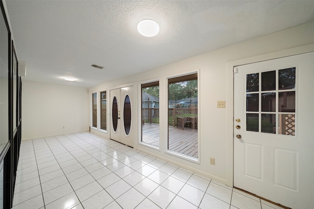 entryway featuring a textured ceiling and light tile patterned flooring