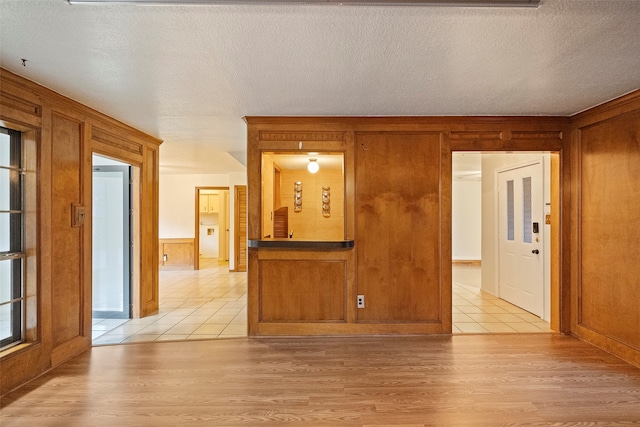 unfurnished room featuring a textured ceiling and light wood-type flooring