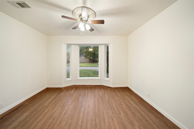 unfurnished room featuring a textured ceiling, ceiling fan, and hardwood / wood-style flooring