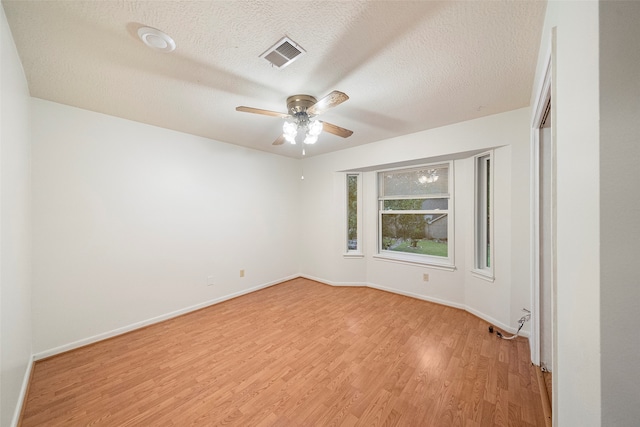 spare room featuring hardwood / wood-style floors, ceiling fan, and a textured ceiling