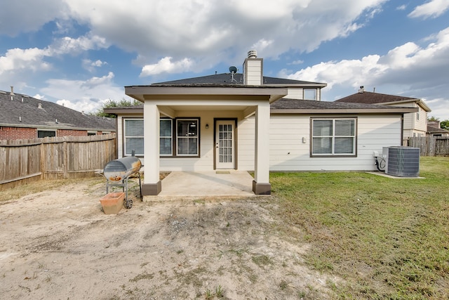 rear view of house with a patio, a yard, and cooling unit