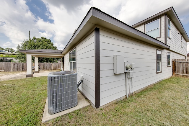 view of side of property with a yard and central AC unit