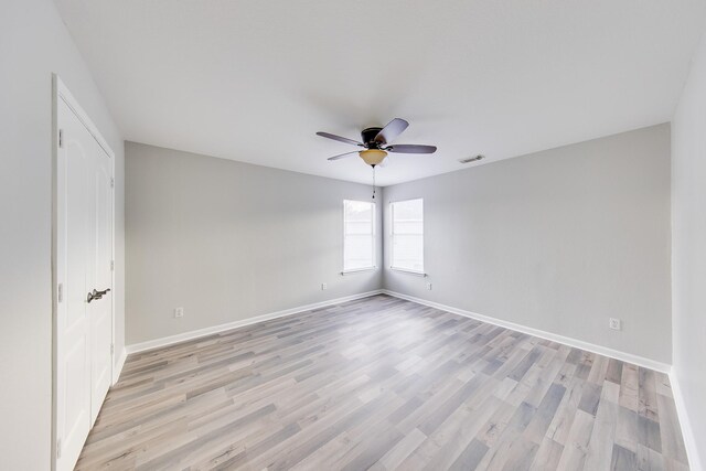 empty room with ceiling fan and light wood-type flooring