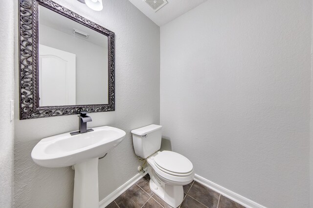 bathroom with toilet and tile patterned flooring