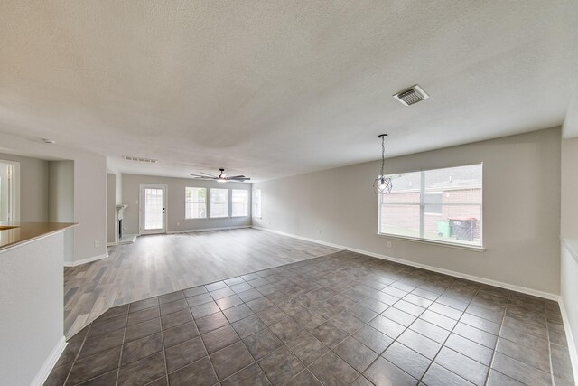 empty room featuring ceiling fan, a textured ceiling, and wood-type flooring