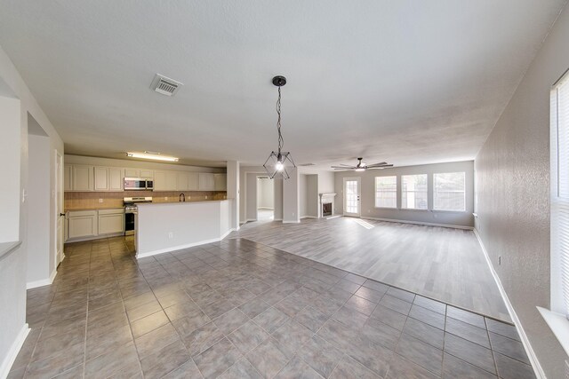 unfurnished living room featuring light wood-type flooring, sink, and ceiling fan