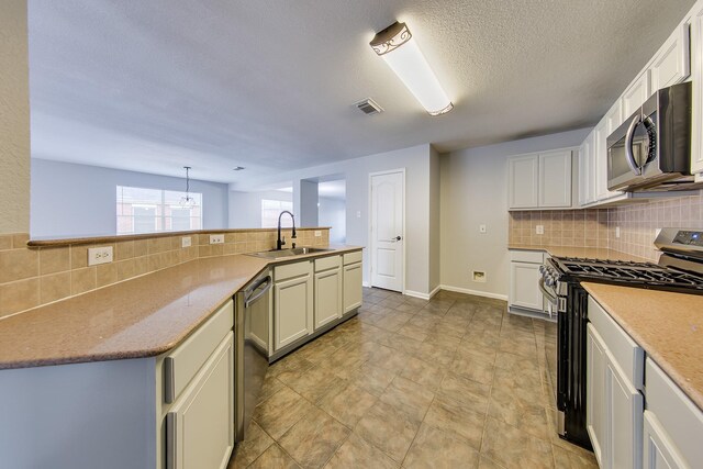 kitchen with backsplash, stainless steel appliances, sink, light tile patterned flooring, and hanging light fixtures