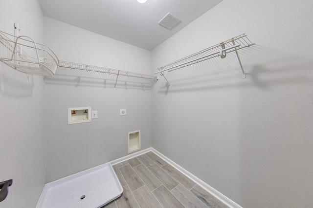 laundry room with hookup for an electric dryer, hookup for a washing machine, and hardwood / wood-style floors