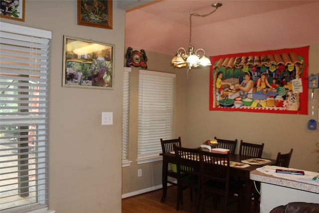 dining area with hardwood / wood-style floors and a chandelier