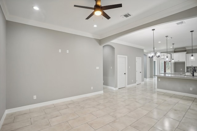 unfurnished living room featuring ceiling fan with notable chandelier, light tile patterned floors, sink, and ornamental molding