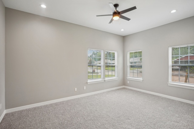 carpeted spare room with ceiling fan