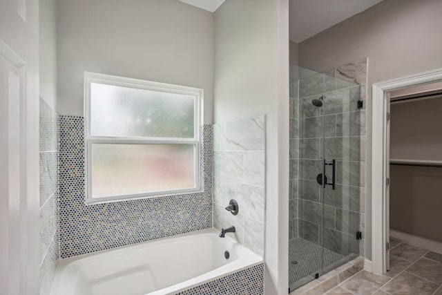 bathroom featuring tile patterned flooring and separate shower and tub