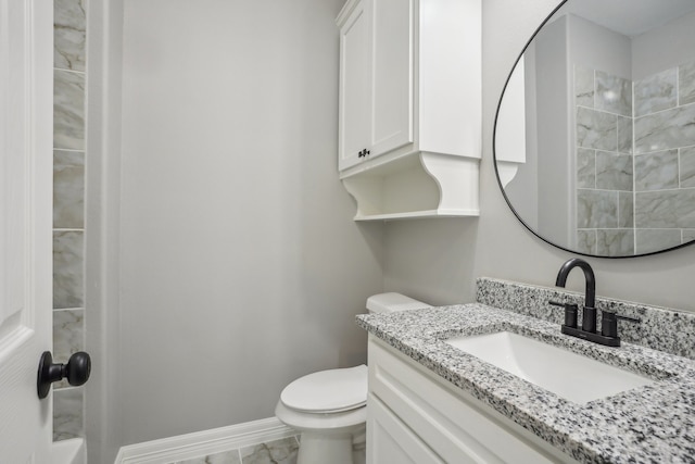 bathroom with vanity, toilet, and tiled shower