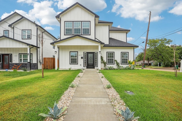 view of front facade featuring board and batten siding, a front yard, and fence