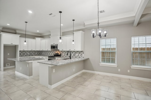 kitchen with appliances with stainless steel finishes, white cabinetry, light stone counters, and decorative backsplash