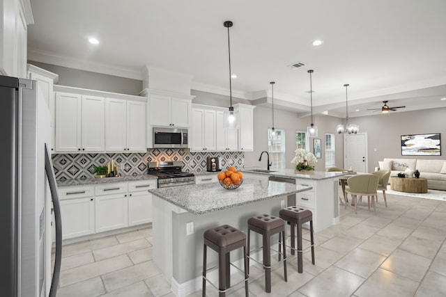 kitchen with white cabinets, appliances with stainless steel finishes, kitchen peninsula, and ceiling fan