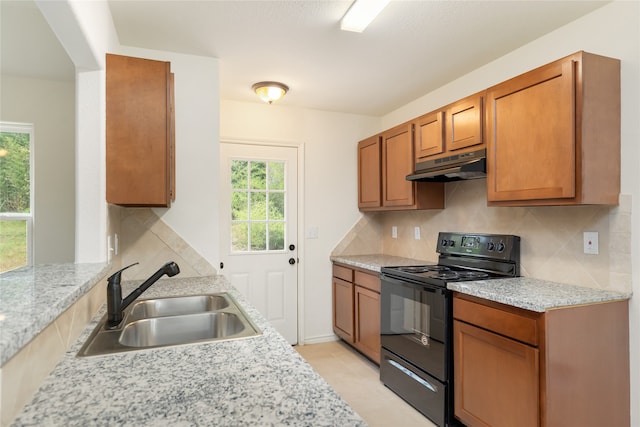 kitchen with a wealth of natural light, sink, black electric range, and decorative backsplash