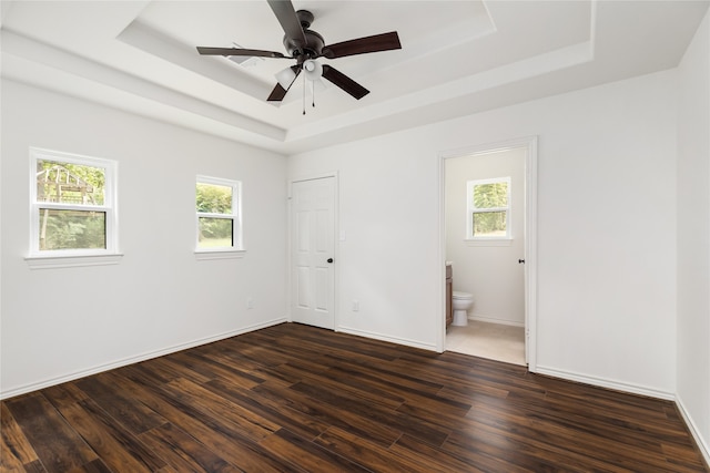 interior space with ceiling fan, a raised ceiling, and a wealth of natural light