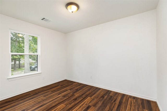 spare room with dark hardwood / wood-style flooring and a healthy amount of sunlight