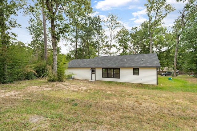 rear view of property featuring a lawn