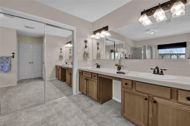 bathroom featuring tasteful backsplash, vanity, and a shower with shower door