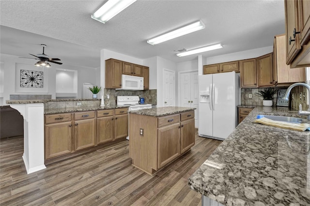 kitchen with a kitchen island, white appliances, ceiling fan, and tasteful backsplash