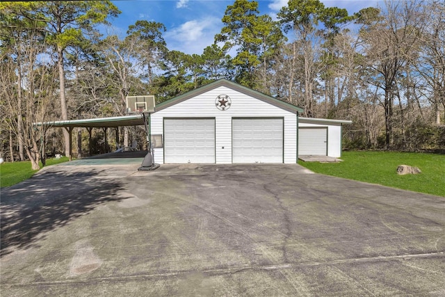 garage featuring a carport and a yard